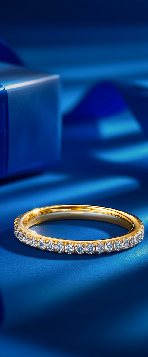 Two sparkling wedding bands on blue surface.