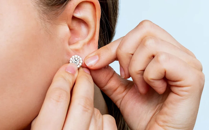 Woman putting diamond earring on