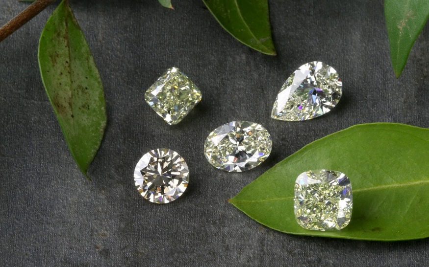 Lab grown diamonds in different shapes on dark grey surface