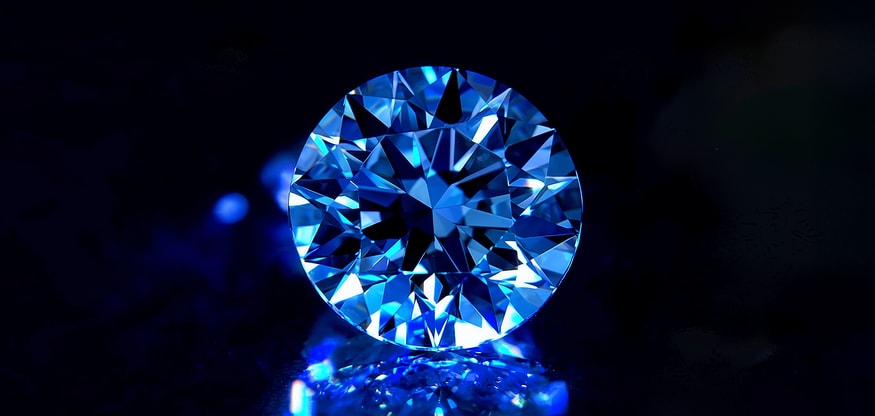A diamond rests elegantly on a table adorned with vibrant blue flowers, creating a striking visual contrast.
